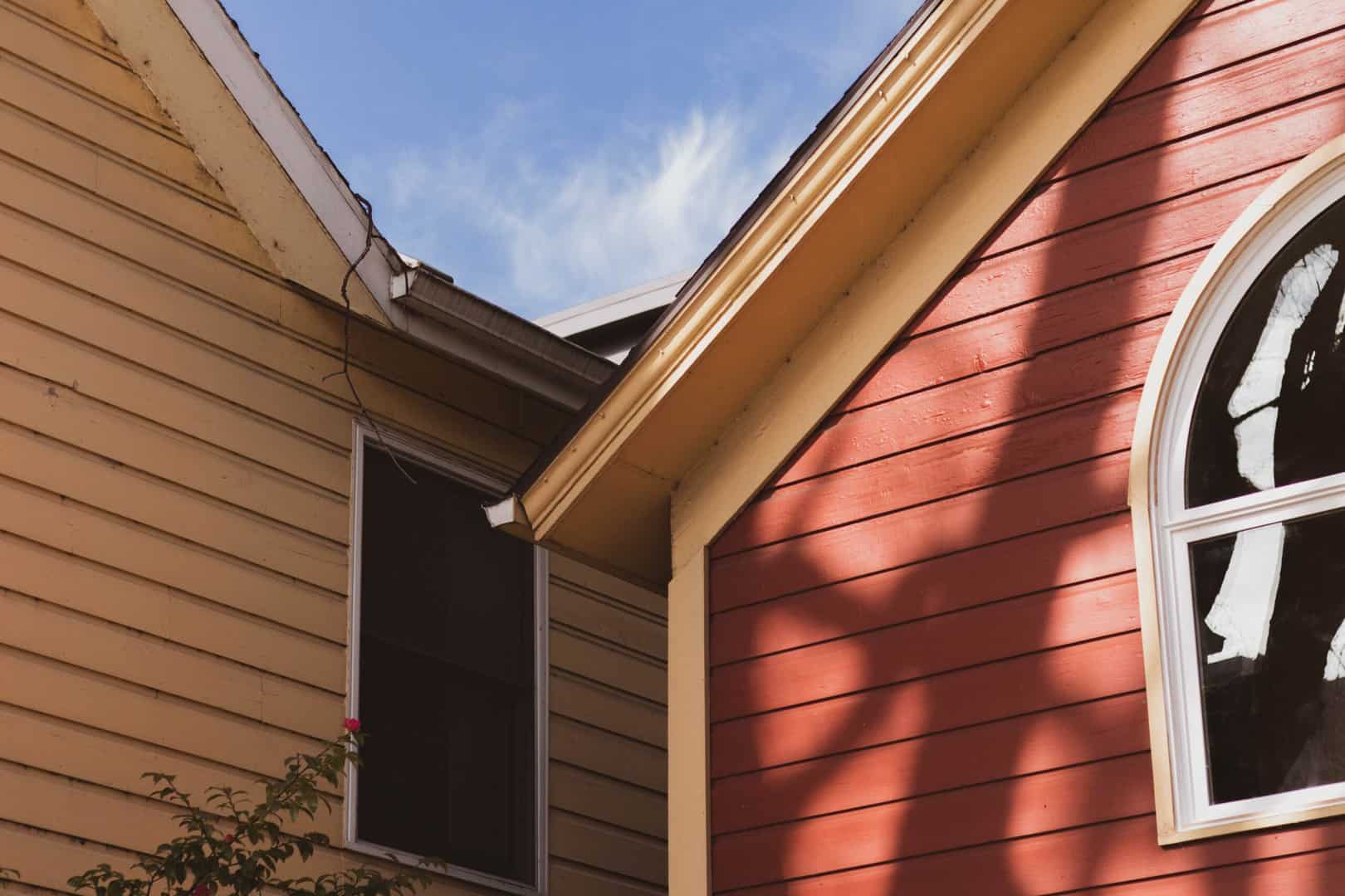 Close up of a house's siding, both red and cream siding installation by local roofing contractor