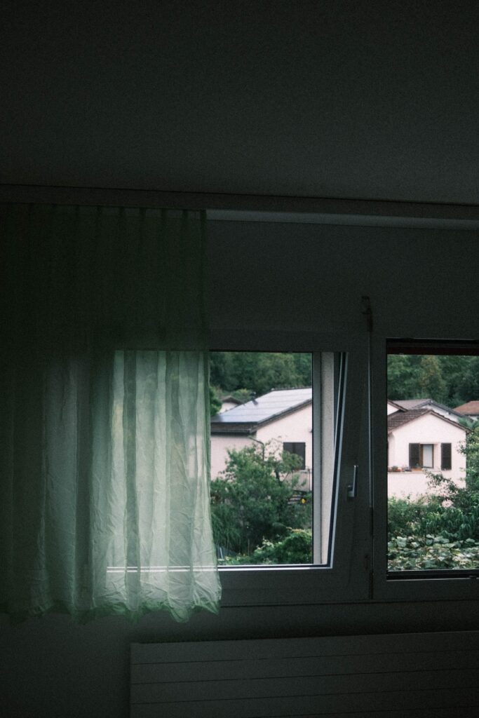 The window of a Charlotte home with a window curtain in front of it.