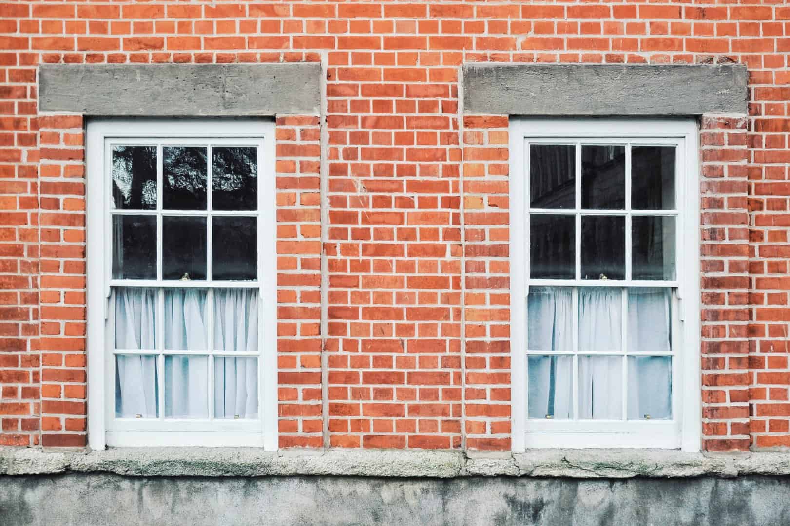 A brick building in Charlotte with two windows.