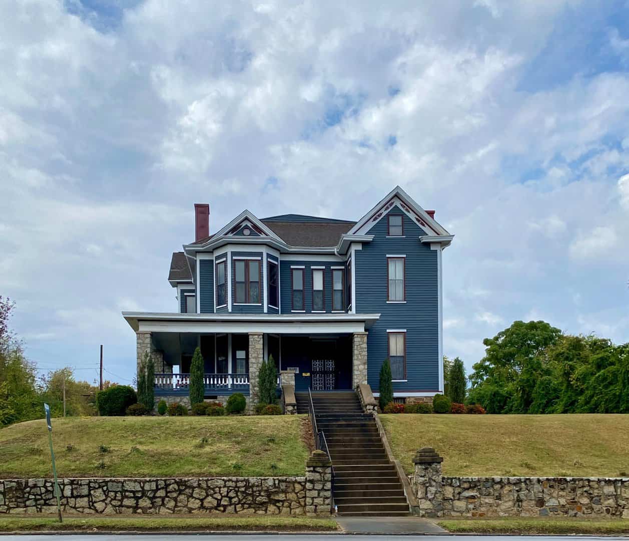 Blue house on a hill with blue sky after roof inspection by charlotte roofing contractot