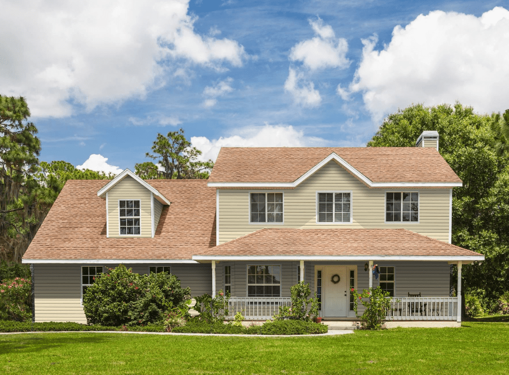 Front of house with beige siding, white gutters and brown roof in Charlotte