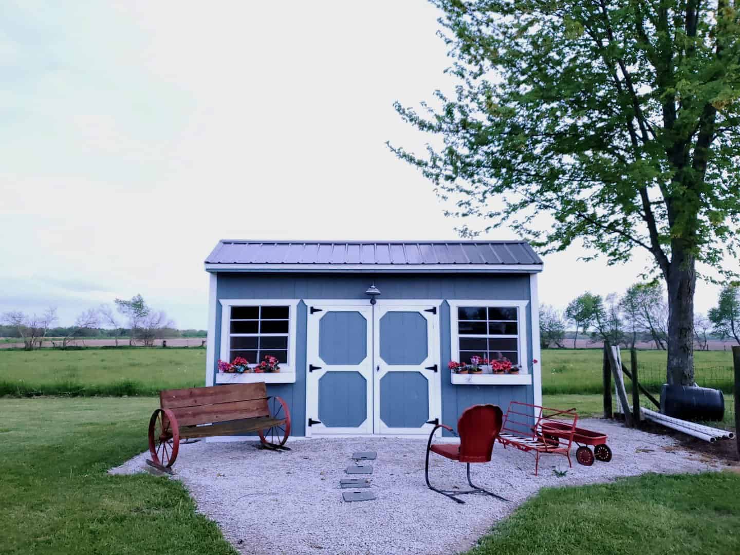 Blue shed with white trim after roof installation by roofing company in charlotte