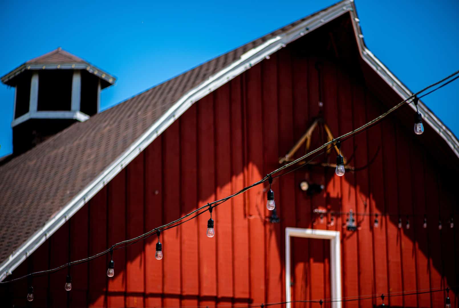 top of red barn with blue sky after a roof installation by Charlotte roofing contractor