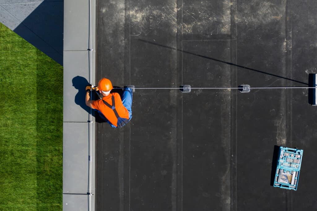 A professional roofing contractor walking on top of a commercial Denver roof.