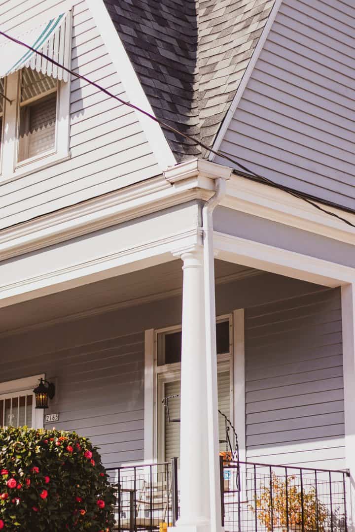 Close up of covered porch corner showing the gutter installation and downspout from local Minneapolis roofing company
