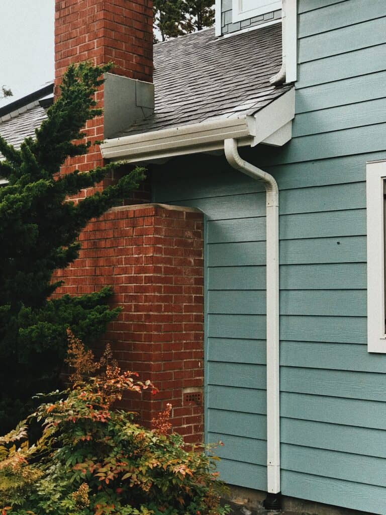 A teal Charlotte home with traditional gutters.